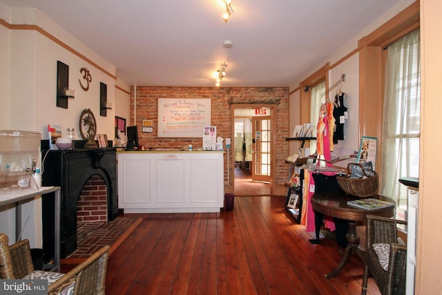 interior space featuring french doors, dark wood-type flooring, a healthy amount of sunlight, and brick wall