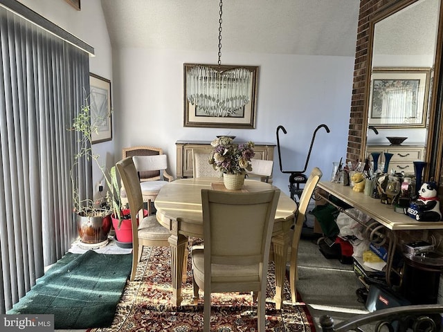 dining room featuring a textured ceiling, an inviting chandelier, and lofted ceiling