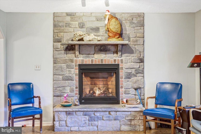 living area featuring a stone fireplace and carpet