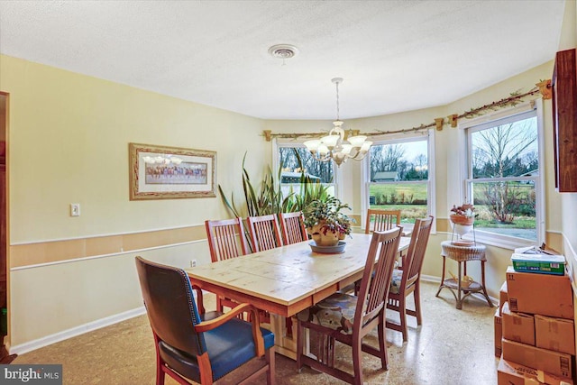 dining area with a textured ceiling and an inviting chandelier