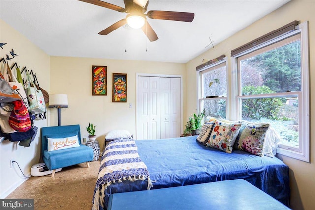 carpeted bedroom featuring ceiling fan and a closet