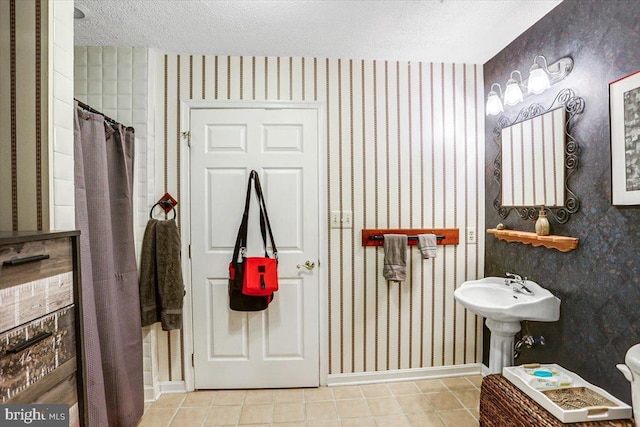 bathroom with tile patterned flooring and a textured ceiling