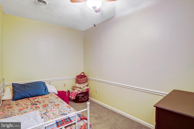 carpeted bedroom featuring a textured ceiling and ceiling fan