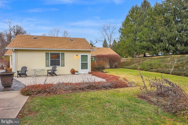 rear view of house featuring a lawn and a patio