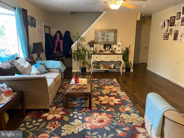 living room with dark hardwood / wood-style floors and ceiling fan