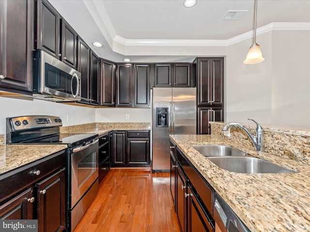 kitchen featuring ornamental molding, hanging light fixtures, stainless steel appliances, and sink