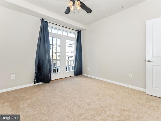 empty room featuring ceiling fan and light carpet