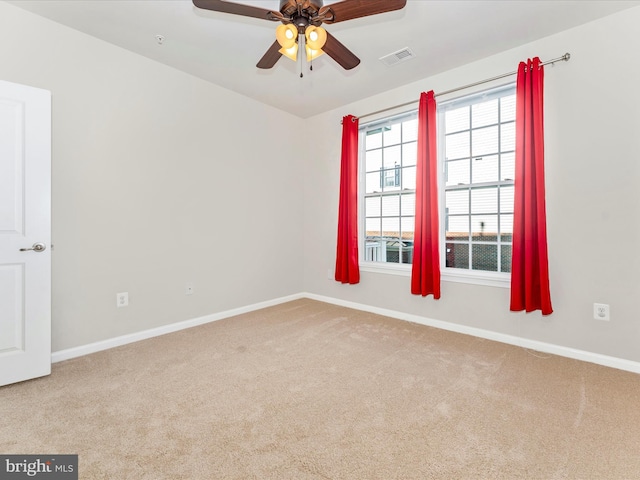 carpeted spare room with ceiling fan