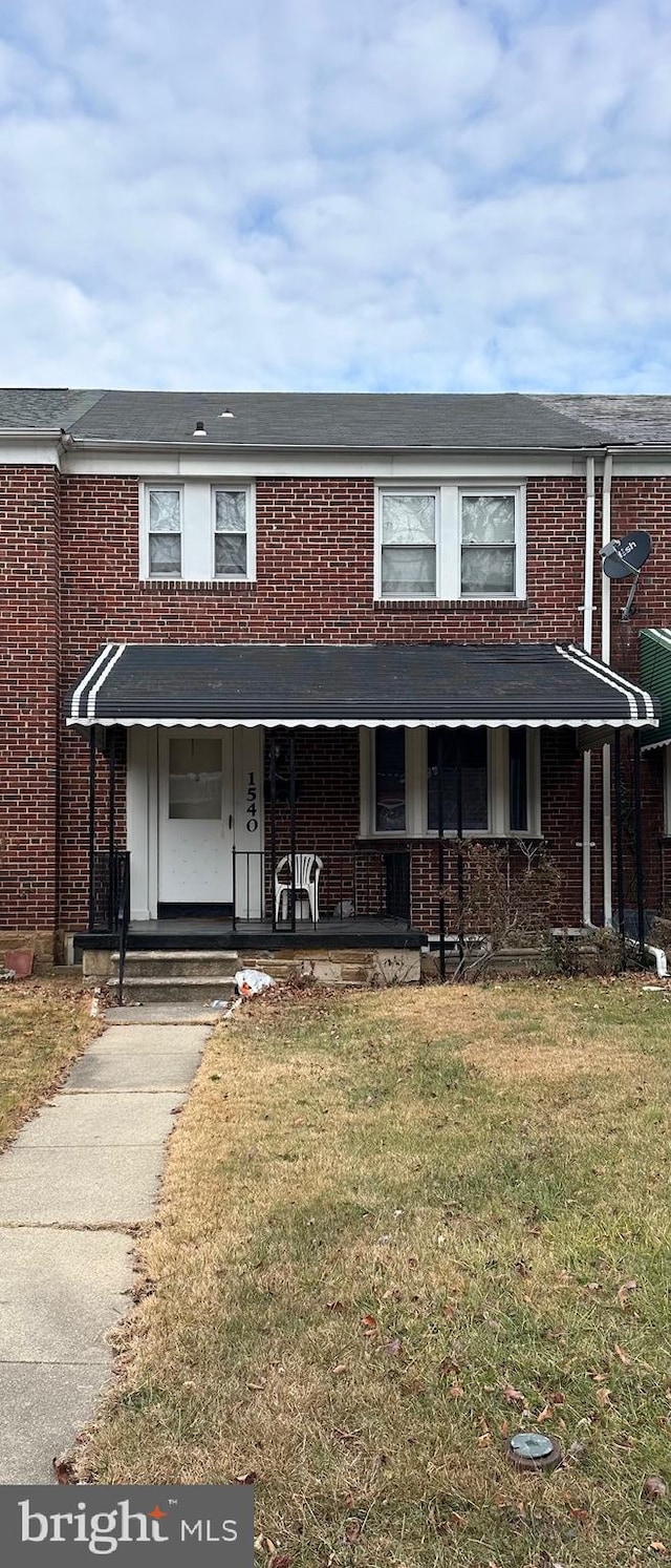 multi unit property with a porch and a front lawn