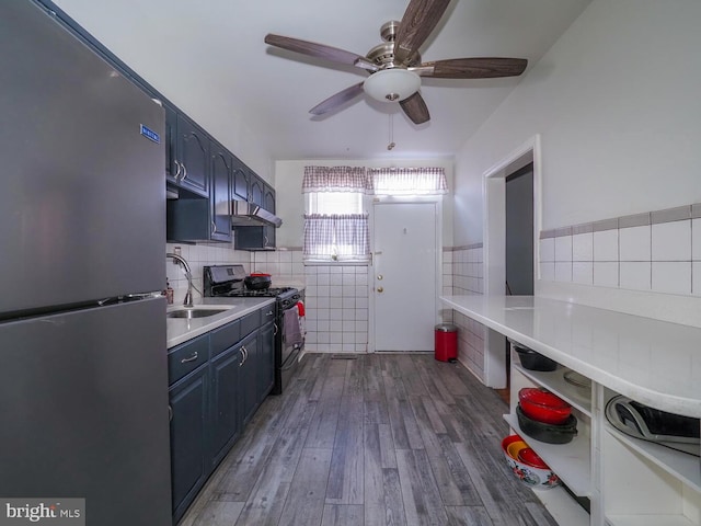 kitchen featuring stainless steel refrigerator, sink, ceiling fan, gas stove, and dark wood-type flooring