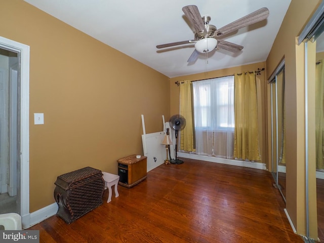 workout area with dark wood-type flooring and ceiling fan