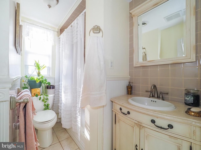 bathroom with vanity, toilet, tile patterned flooring, and backsplash