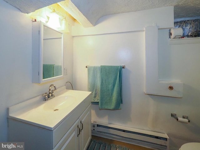 bathroom featuring vanity, a textured ceiling, and baseboard heating