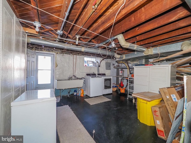 basement with washing machine and dryer, sink, electric panel, and refrigerator