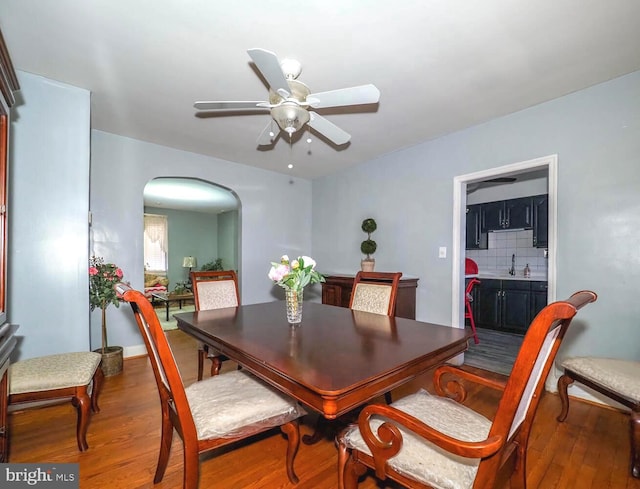 dining area featuring ceiling fan, wood-type flooring, and sink