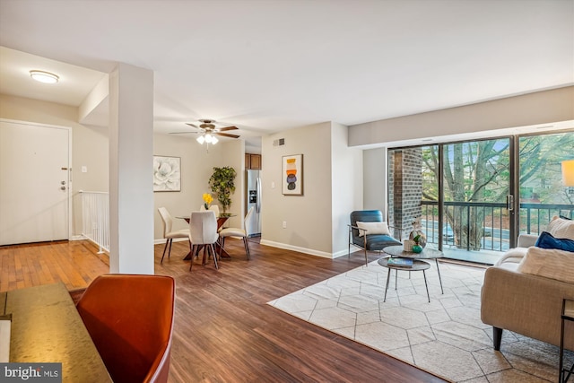 living room featuring ceiling fan and dark hardwood / wood-style flooring