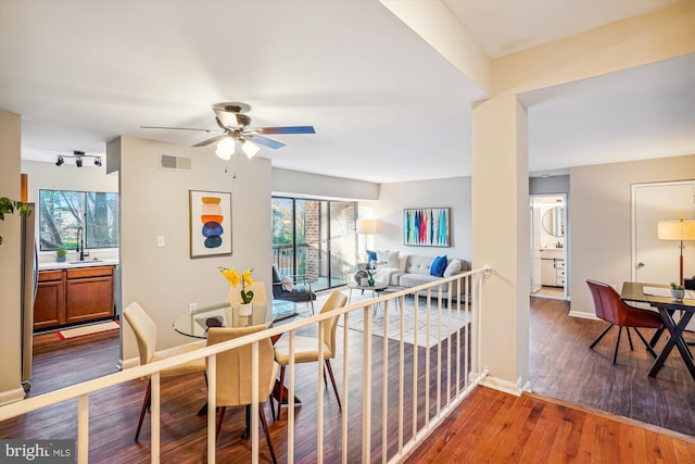 dining room featuring ceiling fan, sink, and dark wood-type flooring