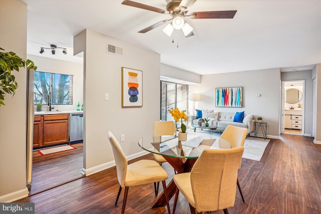 dining room featuring dark hardwood / wood-style flooring, ceiling fan, and sink