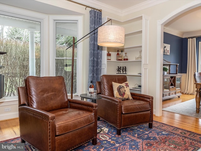 living area featuring hardwood / wood-style floors and ornamental molding