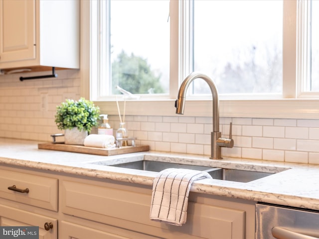 room details with light stone counters, sink, and backsplash