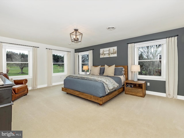 bedroom with carpet and a notable chandelier