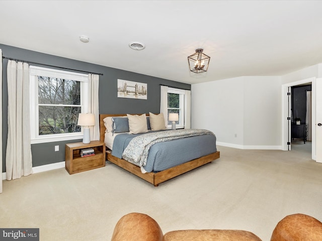 carpeted bedroom with a chandelier and multiple windows