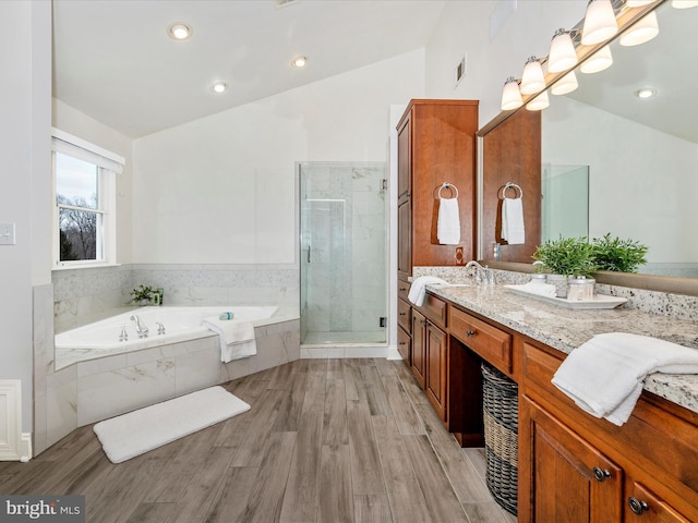 bathroom with wood-type flooring, vanity, shower with separate bathtub, and lofted ceiling