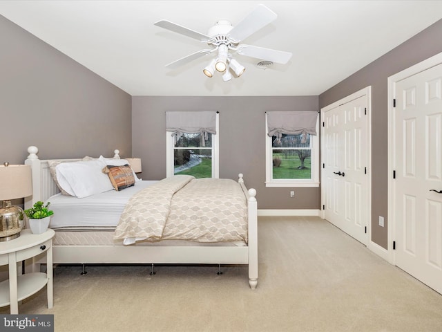 bedroom with ceiling fan and light colored carpet