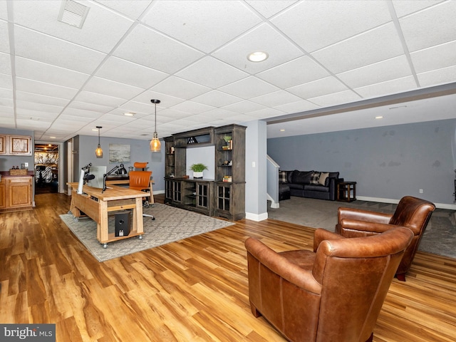 game room with a paneled ceiling and wood-type flooring