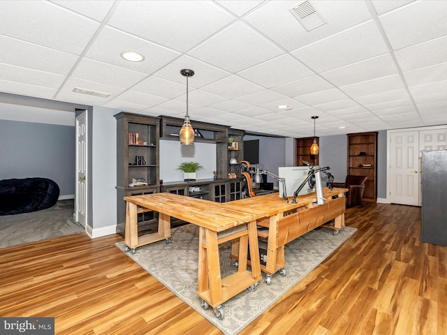 dining area with a paneled ceiling and dark wood-type flooring