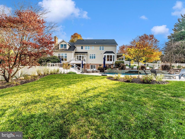 back of property with a swimming pool side deck, a yard, a patio, and an outdoor living space