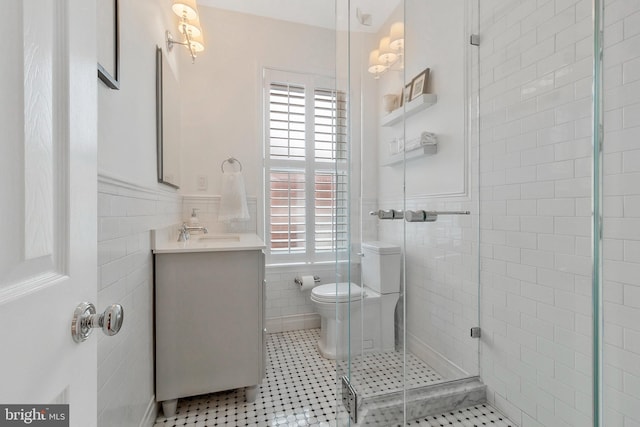 bathroom featuring a wealth of natural light, vanity, tile walls, and toilet