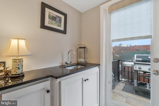 bar featuring white cabinetry and sink