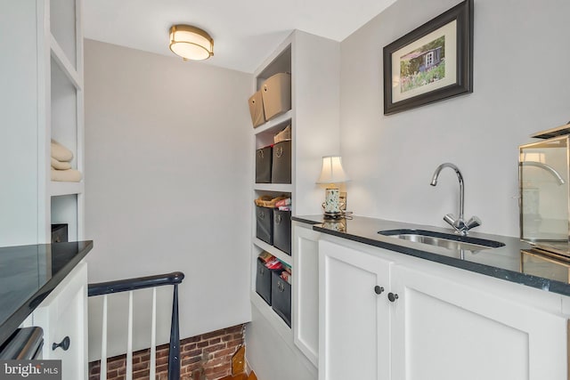 kitchen featuring white cabinetry and sink