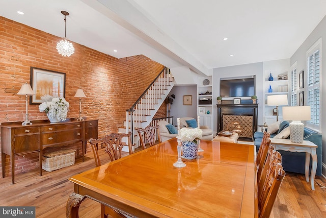 dining room featuring light hardwood / wood-style floors and brick wall