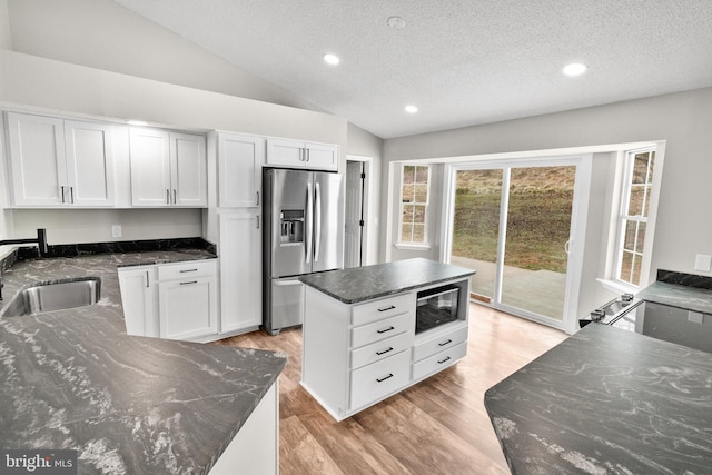 kitchen featuring a textured ceiling, white cabinetry, sink, and stainless steel refrigerator with ice dispenser