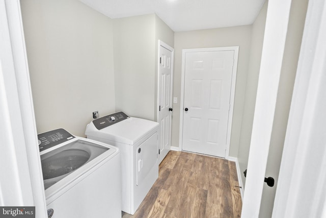 laundry room with hardwood / wood-style flooring and separate washer and dryer