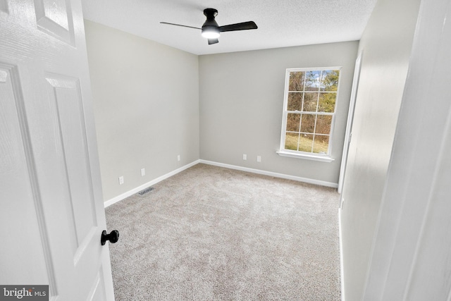 unfurnished room with carpet flooring, ceiling fan, and a textured ceiling