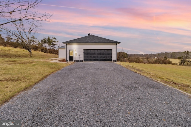 view of front of property with a garage and a yard