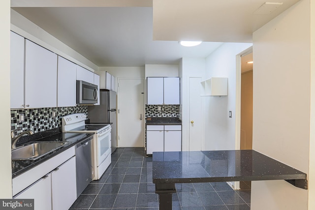 kitchen featuring decorative backsplash, appliances with stainless steel finishes, white cabinetry, and sink