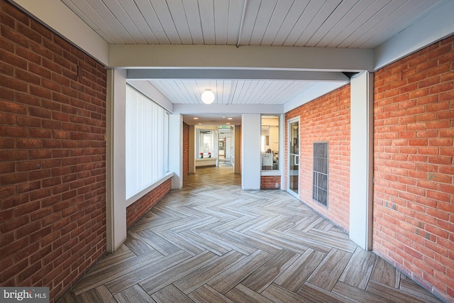 corridor with brick wall and light parquet floors