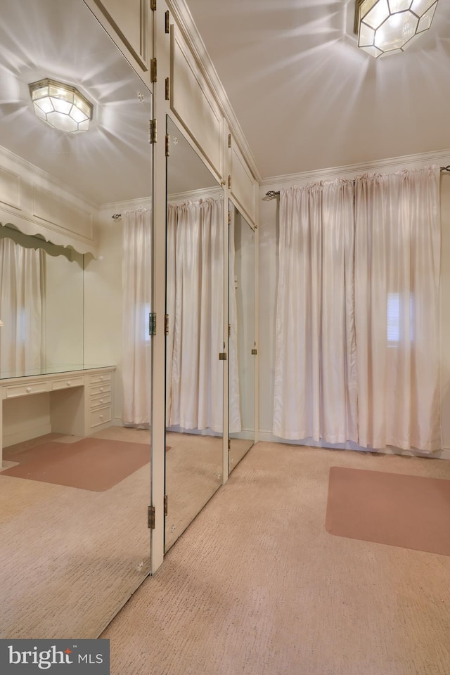 basement with light colored carpet and ornamental molding