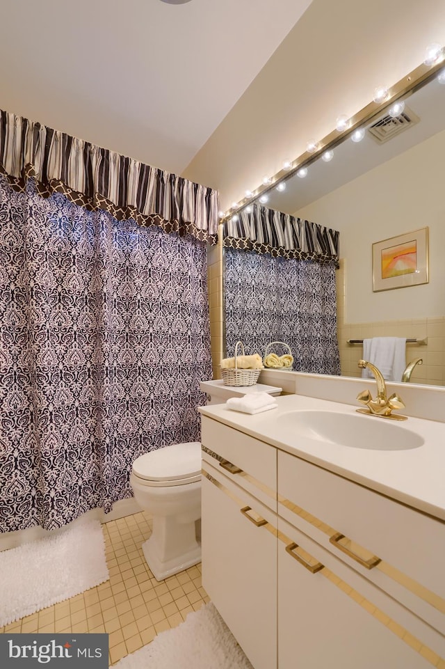 bathroom with tile patterned flooring, vanity, and toilet