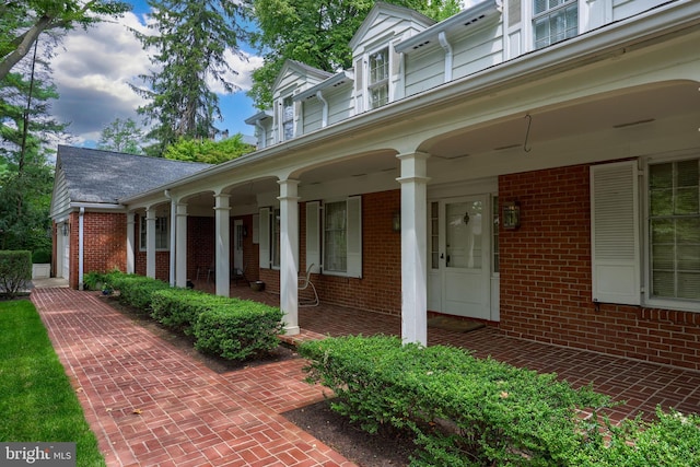 view of side of home featuring covered porch