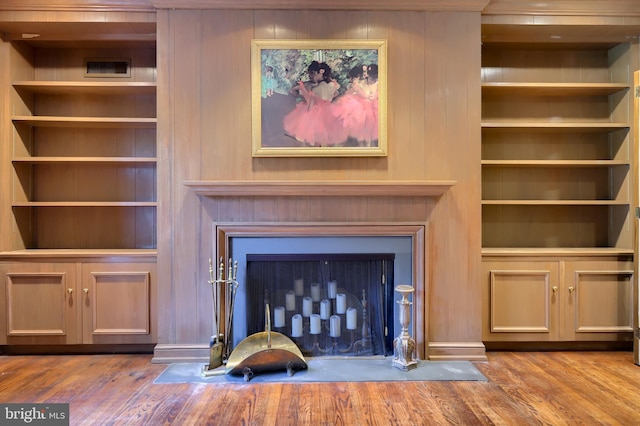 room details with wood-type flooring and built in shelves