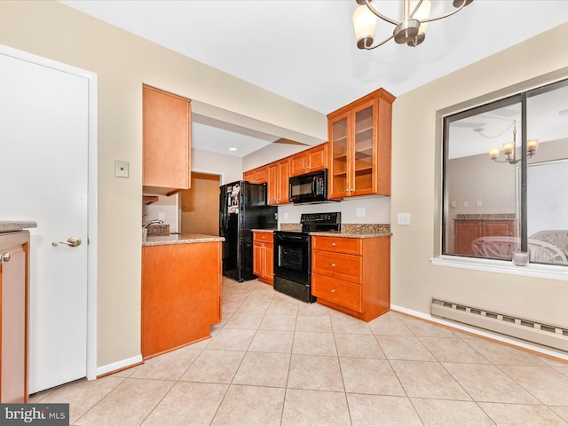 kitchen featuring light stone counters, a baseboard heating unit, black appliances, light tile patterned floors, and an inviting chandelier