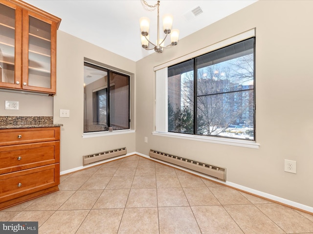 unfurnished dining area featuring a chandelier, light tile patterned flooring, and a baseboard radiator