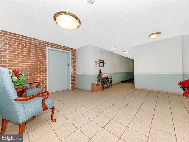 interior space featuring brick wall and a textured ceiling