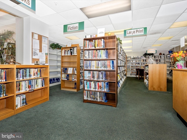 interior space featuring dark carpet and a drop ceiling