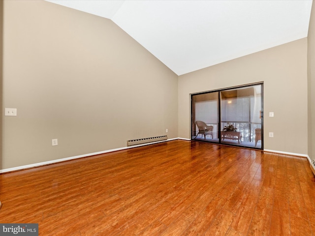 empty room featuring hardwood / wood-style flooring, vaulted ceiling, and a baseboard heating unit